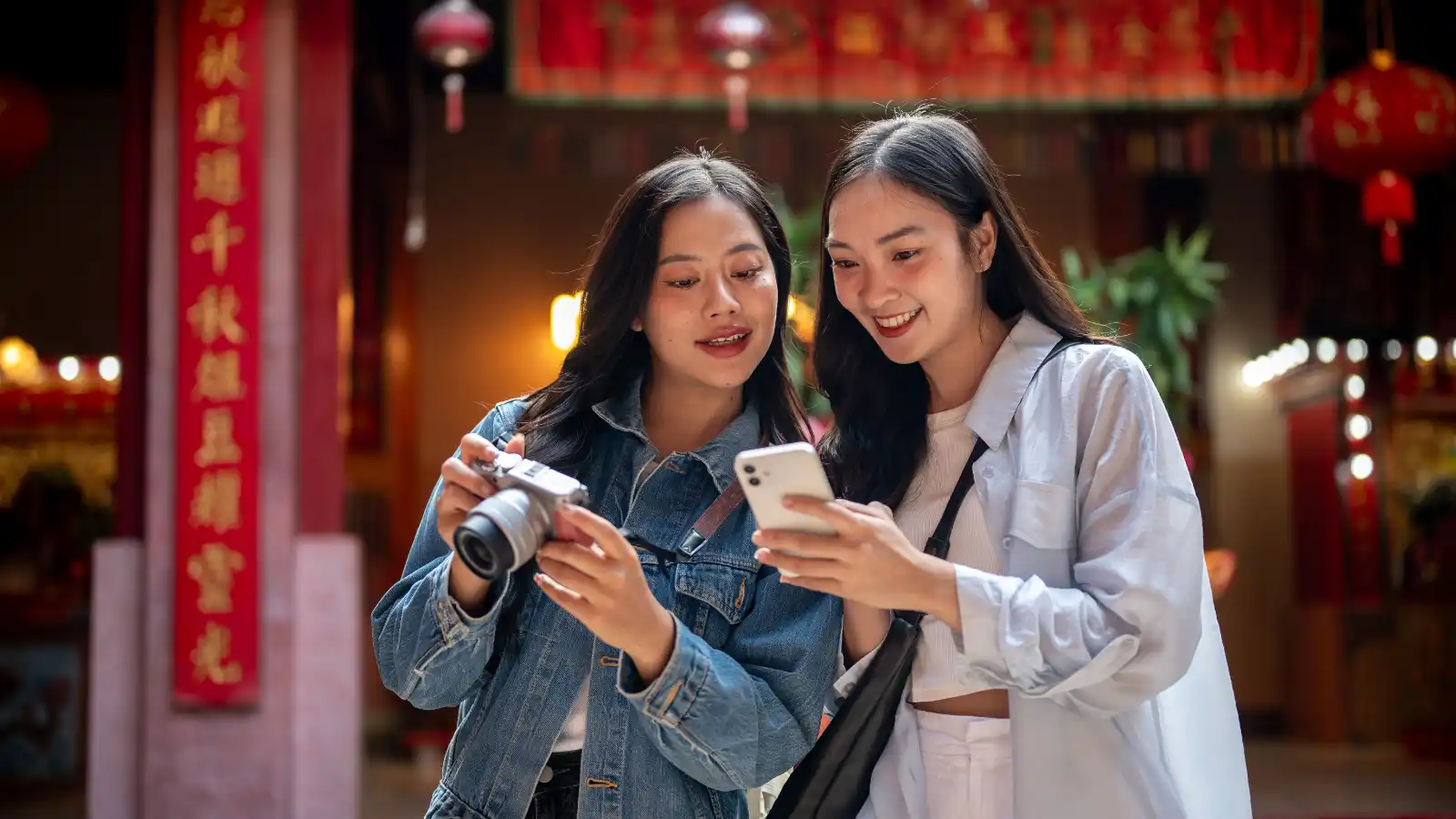 Two friends discovering a brand through influencer content on their phone in Thailand